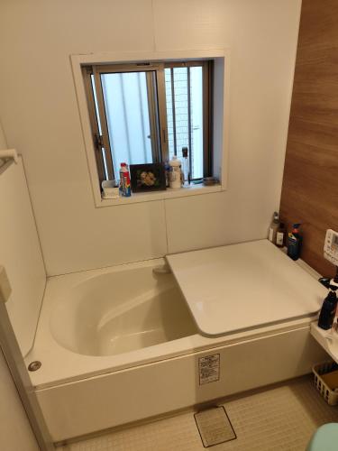 a bath tub in a bathroom with a window at 関東最大のスパが身近にあり二部 in Niizo