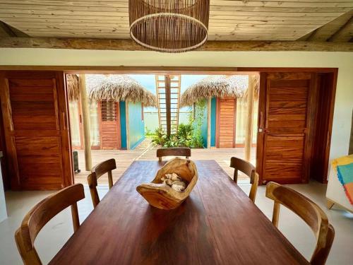 ein Esszimmer mit einem Holztisch mit einer Tasche darauf in der Unterkunft Vila Carnaúba - Piscina e luxo in Fortim