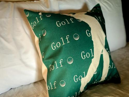 a green pillow with the words golf club on it at Putters Paradise-2bed2bathgrillfirepit-10pp in Osage Beach
