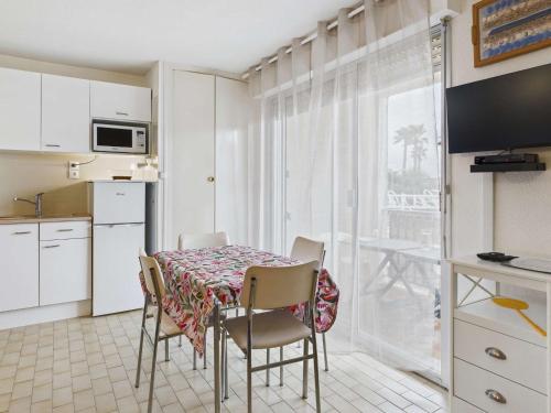 une cuisine avec une table et des chaises dans une cuisine dans l'établissement Appartement 2 pièces à Marseillan-Plage avec Parking et Climatisation - FR-1-326-853, à Marseillan