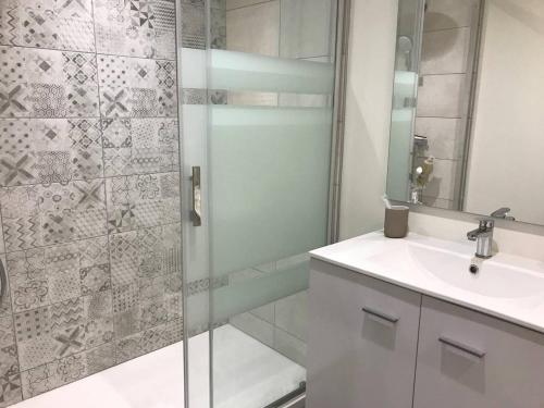 une salle de bain avec un lavabo et une douche dans l'établissement Appartement lumineux au centre de Cauterets avec terrasse et garage - FR-1-812-136, à Cauterets