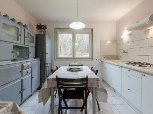 une cuisine avec une table et des chaises ainsi qu'une fenêtre dans l'établissement Gîte indépendant avec étang - 3 chambres, animaux admis - FR-1-583-382, à Gy