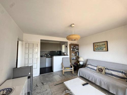 un salon avec un canapé et une cuisine dans l'établissement Charmant appartement avec parking et A/C proche plage - FR-1-100-357, à Cavalaire-sur-Mer