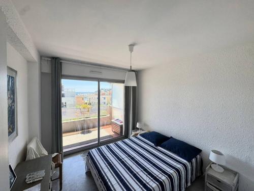 une chambre avec un lit et une grande fenêtre dans l'établissement Charmant appartement avec parking et A/C proche plage - FR-1-100-357, à Cavalaire-sur-Mer