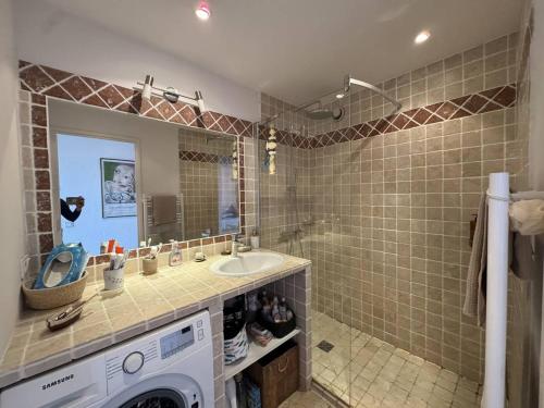 une salle de bain avec un lavabo et une machine à laver dans l'établissement Charmant appartement avec parking et A/C proche plage - FR-1-100-357, à Cavalaire-sur-Mer