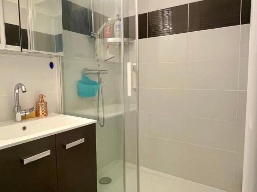 une salle de bain avec une douche en verre et un lavabo dans l'établissement Superbe appartement avec piscine et parking sécurisé - FR-1-748-33, à Canet