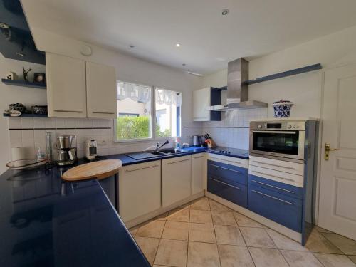 - une cuisine avec des placards bleus et blancs et un évier dans l'établissement Maison moderne 8 pers à St Gildas de Rhuys, près du bourg et falaises - FR-1-775-29, à Saint-Gildas-de-Rhuys