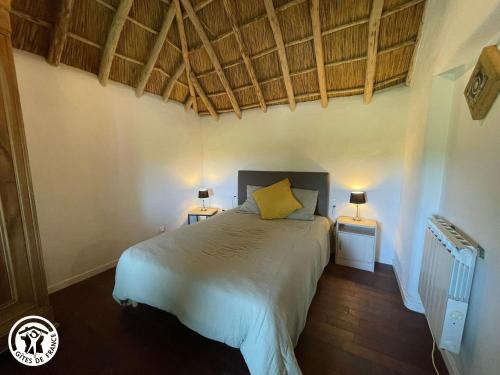 a bedroom with a bed and two night stands with lamps at Charmante chaumière traditionnelle dans le Marais breton - FR-1-426-584 in Beauvoir-sur-Mer