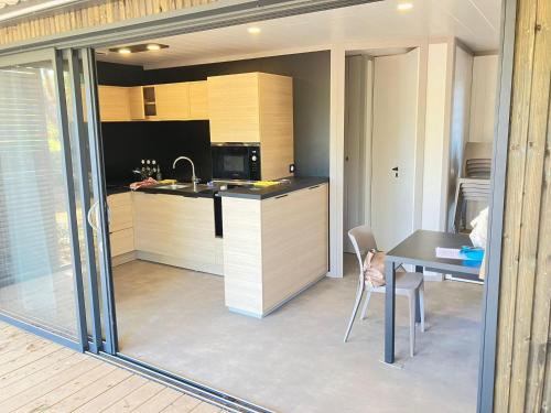 une cuisine avec un bureau et une table avec une chaise dans l'établissement Chalet 3 chambres proche plages et Canal du Midi ! - FR-1-783-49, à Agde