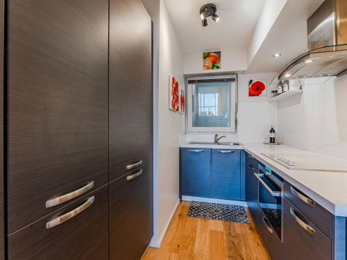 une cuisine avec des armoires bleues et un évier dans l'établissement Arcachon : T3 Confortable à 80m Plage - Parking Inclus - FR-1-433-141, à Arcachon