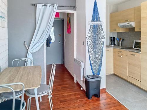 - une petite cuisine avec une table et un bateau sur le mur dans l'établissement Appartement en Front de Mer avec Parking et WIFI, 4 Couchages - FR-1-746-30, à Courseulles-sur-Mer
