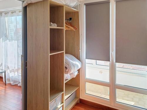 un placard avec des étagères en bois et une fenêtre dans l'établissement Appartement en Front de Mer avec Parking et WIFI, 4 Couchages - FR-1-746-30, à Courseulles-sur-Mer