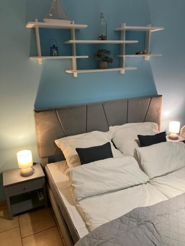 un lit avec des oreillers blancs dans une pièce avec des lumières dans l'établissement Apartament Nostalgia, à Gąski