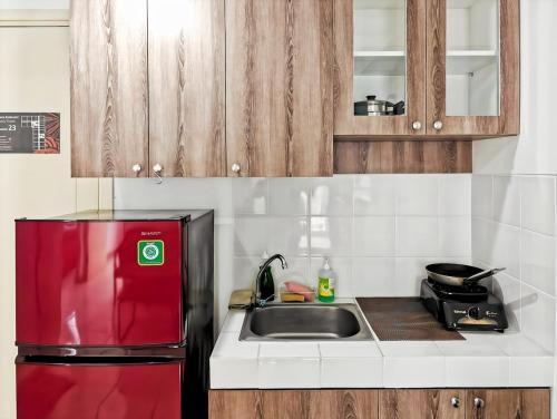 a kitchen with a red refrigerator and a sink at Cozy 3BR M-Town apt Serpong with Pool by 2ndHome in Pumpangsineng