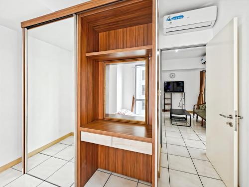 a room with a wooden door and a mirror at Cozy 3BR M-Town apt Serpong with Pool by 2ndHome in Pumpangsineng