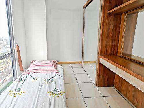 a small bedroom with a bed and a window at Cozy 3BR M-Town apt Serpong with Pool by 2ndHome in Pumpangsineng