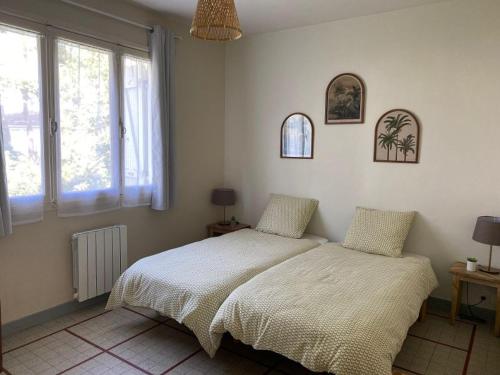 une chambre avec deux lits et deux fenêtres dans l'établissement Maison de Vacances Confortable, Plage à Pied - La Tranche-sur-Mer, 6 Pers., Wifi, Parking, 500m² Terrain - FR-1-22-364, à La Tranche-sur-Mer