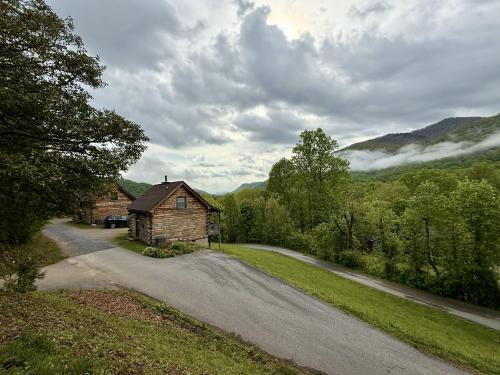 una casa al lado de un camino de tierra al lado de una carretera en Cozy Bear Cabin-Stunning Mountain View, Dogs welcome with Pet Rate, en Maggie Valley