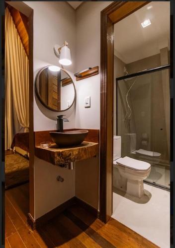 a bathroom with a sink and a toilet and a mirror at Chales da Ilha in Alter do Chao