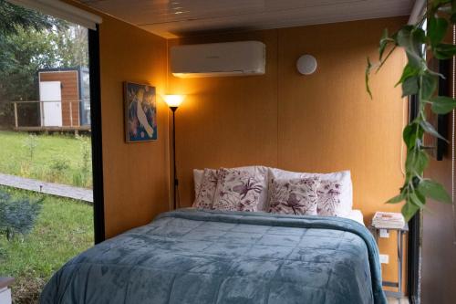 a bedroom with a bed in a room with a window at Little Enniskillen by Tiny Away in Kurrajong