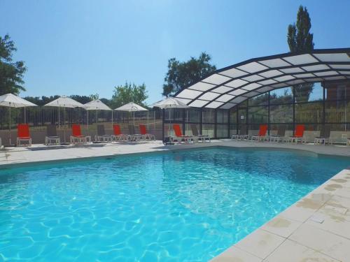une grande piscine avec chaises et parasols dans l'établissement Apartment in Loire Valley near Château Amboise, à Amboise