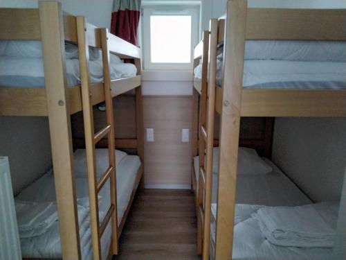 Ce dortoir comprend 4 lits superposés et une fenêtre. dans l'établissement Apartment in Alsace with Heated Pool & Sauna, à Saales