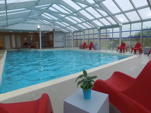 - une grande piscine avec des chaises rouges dans un bâtiment dans l'établissement Apartment on Opal Coast near Protected Beach, à Sangatte Blériot-Plage