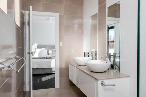 a bathroom with two sinks and a bed at Belle Maison - Glenelg, Cafe, Family, Beach in Glenelg