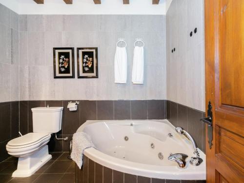 a bathroom with a white tub and a toilet at Cottage in Navas de Estena with Pool & Jacuzzi in Navas de Estena