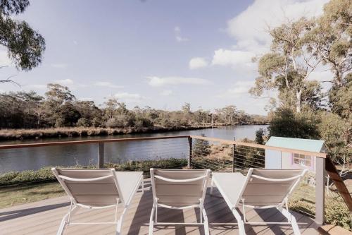 una terraza con sillas y vistas al río en Little Swanport River Haven, en Little Swanport