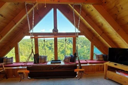 a room with a hanging bed in a cabin at Bearadise Romantic Swing MtnViews*Hottub Easy Road in Williamsburg