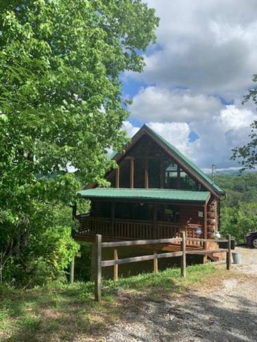 a log cabin with a fence in front of it at Bearadise Romantic Swing MtnViews*Hottub Easy Road in Williamsburg
