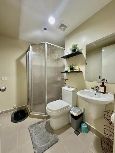 a bathroom with a toilet and a shower and a sink at Pool View Cozy 1-Bedroom Unit Avida Aspira Tower 2 in Cagayan de Oro