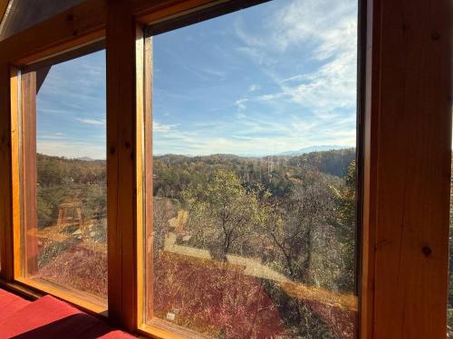 a window with a view of a forest at Bearadise Romantic Swing MtnViews*Hottub Easy Road in Williamsburg