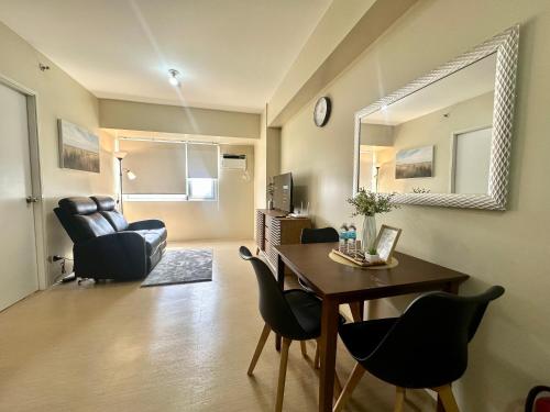 a living room with a dining room table and chairs at Pool View Cozy 1-Bedroom Unit Avida Aspira Tower 2 in Cagayan de Oro