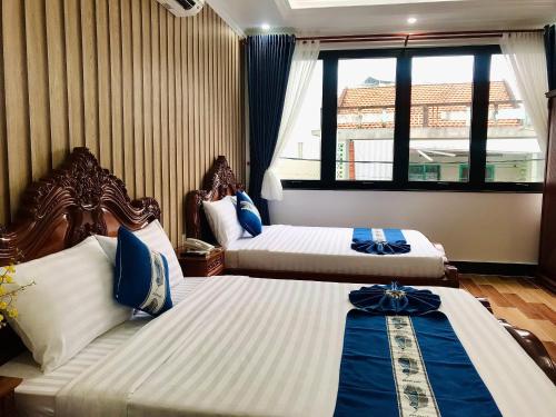 a hotel room with two beds and a window at Cozy 86 Homestay in Can Tho