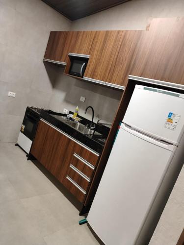 a kitchen with a white refrigerator and a sink at Sua casa na serra in Bezerros