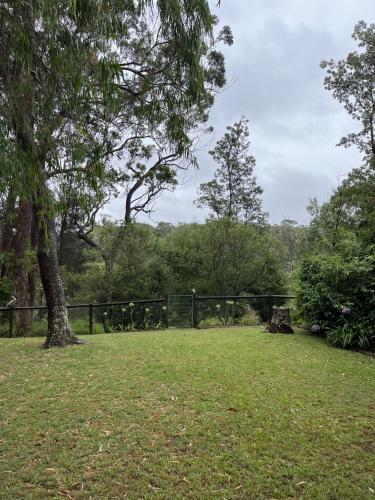 a park with a fence and a tree at Australian Beach and Sea Haven in Broulee