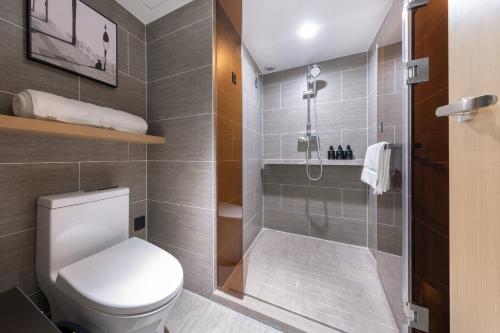a bathroom with a toilet and a shower at Atour Hotel Suzhou Guanqian Street Leqiao Station in Suzhou