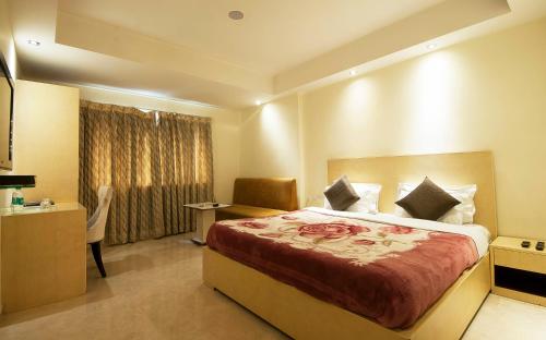 Habitación de hotel con cama y escritorio en Mayur Hotel, en Nueva Delhi