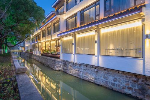 a building with windows next to a river at Atour Hotel Suzhou Guanqian Street Leqiao Station in Suzhou