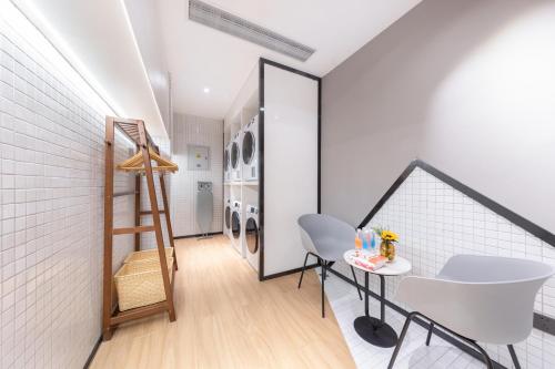 a laundry room with a ladder and a table at Atour Hotel Suzhou Guanqian Street Leqiao Station in Suzhou