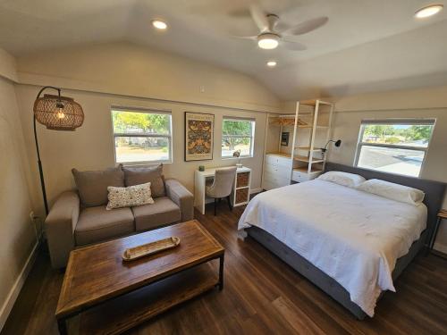a bedroom with a bed and a couch and a table at Villa del Sol St Pete The Loft in St. Petersburg