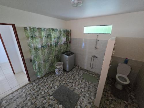 een badkamer met een toilet en een douche met een raam bij Te Anuanua Lodge in Avatoru