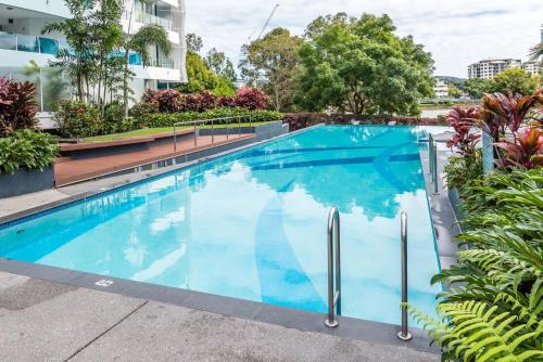 a swimming pool with blue water in a building at Riverside at WaterEdge West End in Brisbane