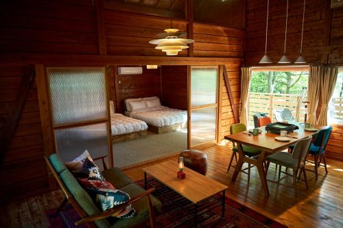 a living room with a table and a bedroom at nasusatoyamafield in Otawara