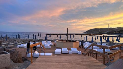 een dok met witte stoelen en een pier met de oceaan bij Blue Marin Apartment in Sanremo