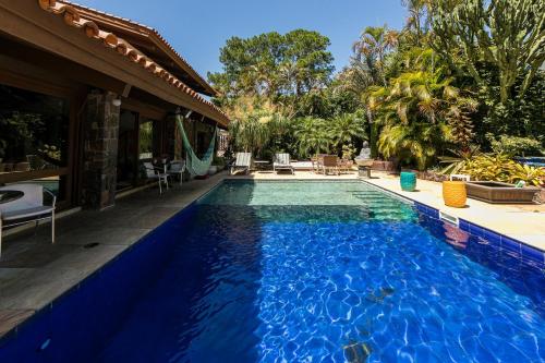 a swimming pool in front of a house at Vila Balinesa in Porto Alegre