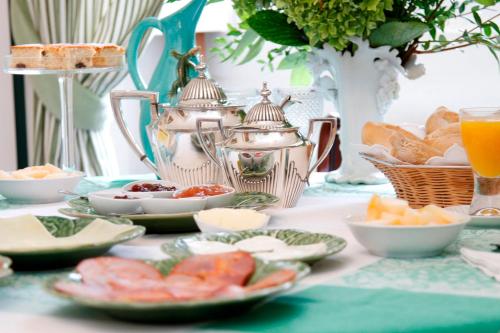 een tafel met borden eten en een waterkoker bij Casa de Mogofores in Anadia