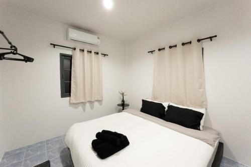 a bedroom with a white bed and a window at Neo Haus Fishermans Village Bophut in Ko Samui